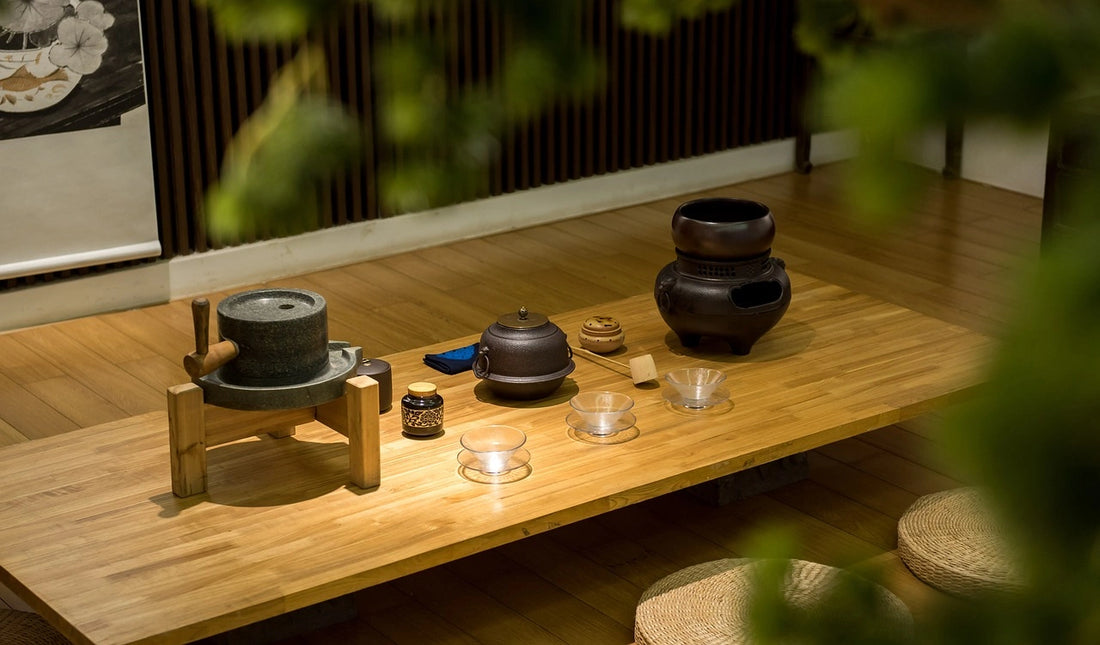 Bouilloire et théière traditionelles japonaises sur une table basse en bois avec trois petits verres transparents