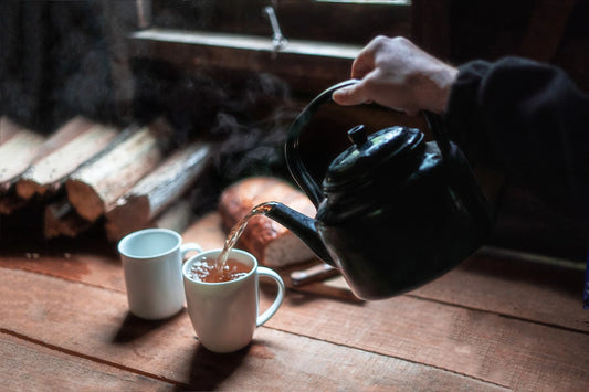 Une théière verse du thé dans une tasse