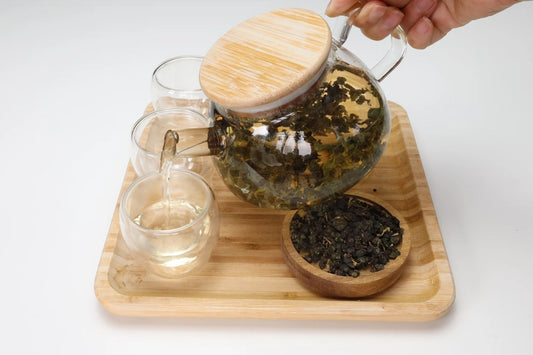 Thé oolong dans une théière en verre transparente.